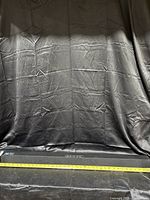 Front view of the black sound bar with measuring tape indicating length.