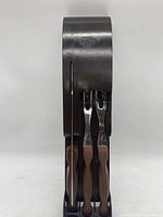 Top view of black plastic hanging utensil organizer holding three utensils with wooden handles.