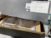 Partially open box revealing the new, unused buffet server inside packaging.