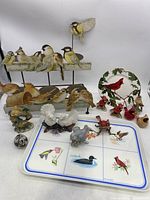 Overall view of multiple bird figurines, metal candle stand with bird figurines, and Paul Giannini bird tray with painted bird images.