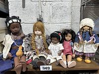 Front view of the five dolls arranged side-by-side showing detailed clothing and facial features.