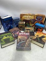 Full lot arranged including 6 hardcover books, 3 audiobook cassette sets, and board game.