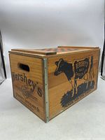 View of the wooden crate side displaying black cow and Hershey's Milk Chocolate promotional text.