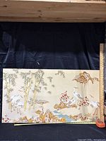 Full view of Japanese canvas print artwork showing cranes, bamboo, rocky landscape, and floral accents on beige canvas.