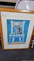 Full view of framed signed print, showing the cat on blue chair artwork.