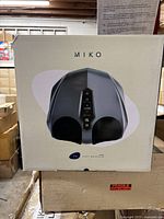 Front view of Miko foot massager box featuring image of device and branding.