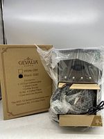 New Gevalia Black G92 coffeemaker in plastic and bubble wrap with control panel and power cord visible, alongside original box showing item details.