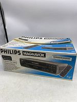 Full view of the Philips Magnavox VCR in original box with remote image on box.