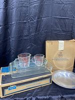 Photo showing boxed Regal chicken fryer pan alongside Pyrex dishes and Pfaltzgraff metal dish with box.