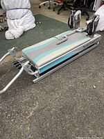 Full side view of Pilates Power Gym reformer showing padded platform and attached foot straps