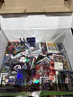 Box of assorted pre-owned football and basketball cards, various designs visible