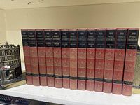 Full view of 12 red hardcover volumes of The Pocket University with gold and black embossed spine text arranged on a shelf.