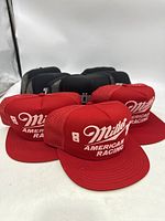 Three red Miller American Racing trucker hats with white embroidered logo, front foam panels and mesh backs