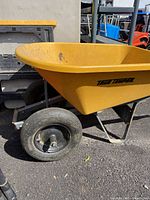 Close-up of wheel showing black solid tire and metal hub attached to the metal frame.