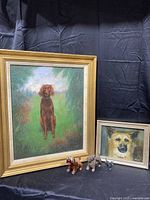 Photo showing large brown dog oil painting, smaller dog face oil painting, and three cast iron Scottie dog figurines
