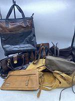 Grouping of seven vintage woman's purses in various colors and styles, showing overall lot contents.