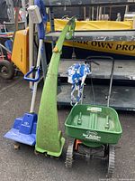 Overview image showing three yard tools: green electric tiller, blue Snow Joe tool, and green Scotts spreader.