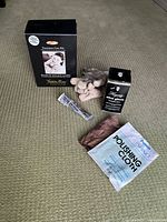 Overview of all items in the lot on carpet: Guardsman furniture care kit products and cleaning cloths next to Hagerty Silver Care accessories including polish and polishing cloths.