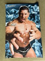 Full view of the Dave Bautista wrestling poster showing central image and corner damage.