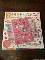 Front of sealed Alex My Sweet Diary box with Dylan's Candy Bar theme, showing colorful candy art, ribbons, and text about stickers and gems included.