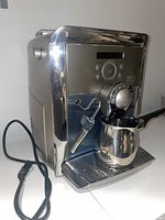 Front angle view showing machine, portafilter and frothing jug