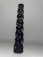 Front view of the tall stacked wooden elephant sculpture showing detail of carvings and color.