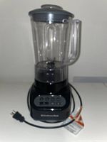 Front view of KitchenAid electric blender showing jar with lid and power cord.