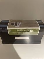 Box containing 3 photo albums stacked horizontally with label showing quantity and general info