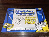 Front of sealed Telestrations 12 Player Party Pack box showing game title, player count, and branding.