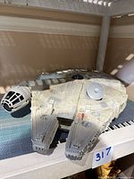 Top view of the 1995 Tonka Millennium Falcon toy showing overall shape, cockpit detail, and wear on paint.