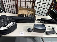 Two Bower Creator lights with tripods, Ouantaray auto zoom lens box, Kodak Ektralite 10 camera, small 200mW camera, TVScope device, and carrying case shown on table.