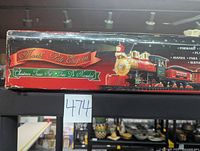 Original box of the North Pole Express Christmas train set showing a vintage red engine illustration covering length of the box