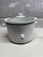 White Rival Crock-Pot slow cooker with glass lid and front manual control knob.
