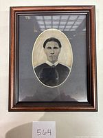 Framed daguerreotype portrait showing the man in an oval image with a wooden frame.