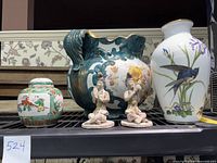 Lot of porcelain and ceramics including a Famille Verte ginger jar, large decorative planter, two clay statues, and a Franklin Porcelain bird vase on shelf