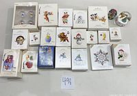 Top-down photo showing 23 assorted Hallmark Keepsake Ornaments in original boxes, various themed characters and years visible.