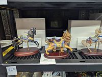 Midnight Charger black carousel horse figurine with floral decorations, displayed with COA and white box in background.