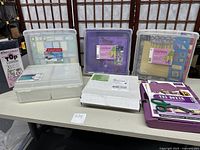 Overview of multiple scrapbook cases, The Boxer box, and crafting kit on a table