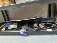 Fishing pole, scuba fins, and skate guards on a shelf with other items.