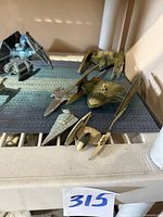 Lot of five Star Wars ships on a blue mat: two Trade Federation Vulture Droids, Naboo Royal Starship, Micro Machines Imperial Star Destroyer, small droid starfighter. Shows wear and surface dirt.
