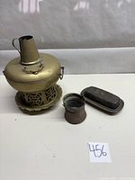 Front view of vintage brass hot pot, small copper pot, and pewter/silver butter dish together on white background