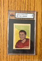 Front of the graded 1952-53 Parkhurst Tony Leswick hockey card #65 showing player illustration in red jersey and KSA grade 2 label.