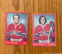 Front view of two 1973-74 O-Pee-Chee hockey cards of Henri Richard and Guy Lafleur wearing Montreal Canadiens jerseys.