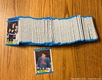 Photo showing the stack of hockey cards, laid out in a row with one card (Mario Lemieux) visible on top and Joe Sakic rookie card laid separately showing the front.