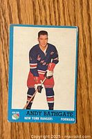 Front image of the Andy Bathgate hockey card showing player in Rangers uniform with blue border and player name.