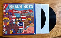 Front view of Beach Boys 'Spirit of America' vinyl album with patriotic cartoon-themed cover and vinyl partially pulled from sleeve.