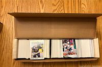 Top view of a large box filled with numerous hockey cards arranged in rows, showing front cards from St. Louis Blues and other NHL teams.