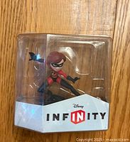 Front view of Mrs. Incredible Disney Infinity figure in clear plastic packaging with Disney Infinity logo.