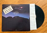 Front cover of Electric Light Orchestra vinyl album showing artwork of a violin and a night sky, with a sticker mentioning the song 'Roll Over Beethoven'. Vinyl record partially visible inside a white protective sleeve.