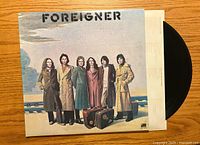 Front cover of Foreigner vinyl album showing band members in coats standing by railroad tracks.